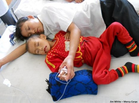 A North Korean mother lies with her acutely malnourished son, plagued by sores, at a county hospital in September 2011. (Photo by Jim White, Mercy Corps) 